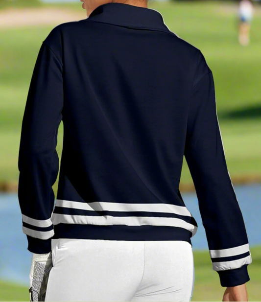 Person wearing a navy blue jacket with white accents on a golf course